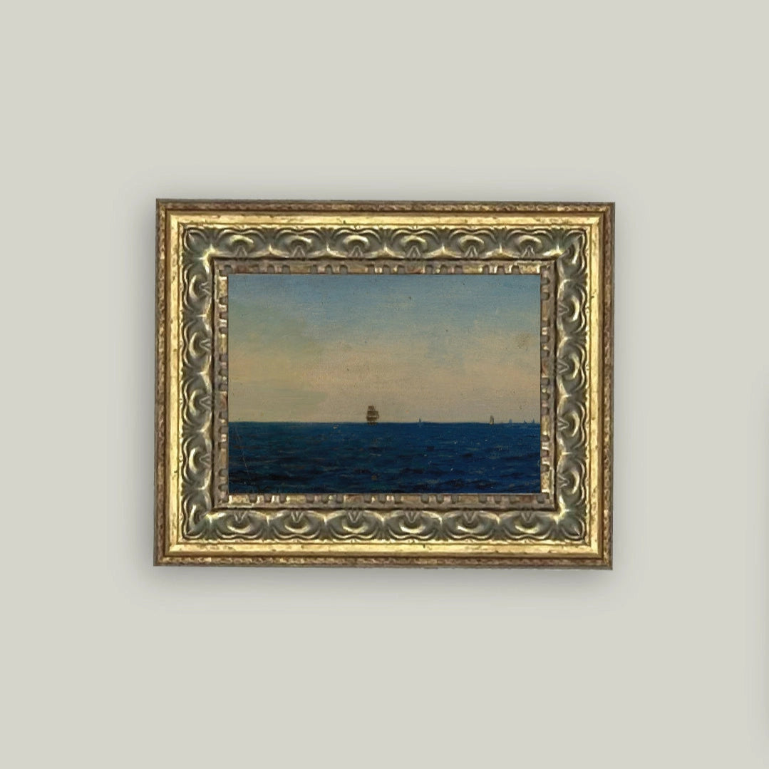 Framed painting of a sailboat on a blue sea with a gray sky.