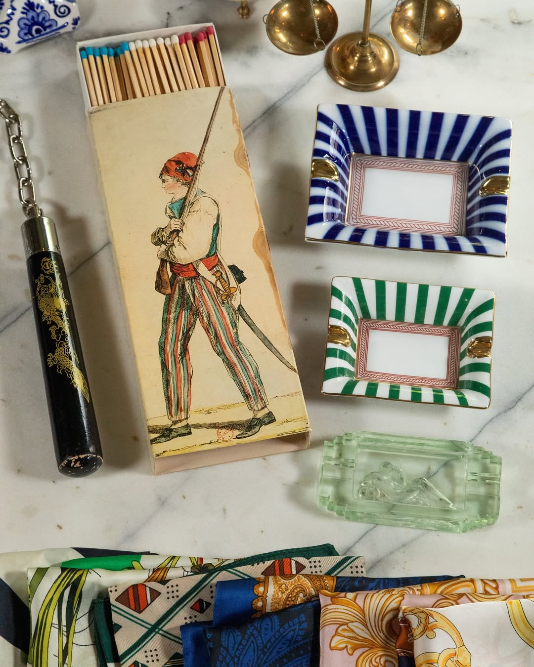 French Matchbox with illustrated character, small decorative items on a marble surface