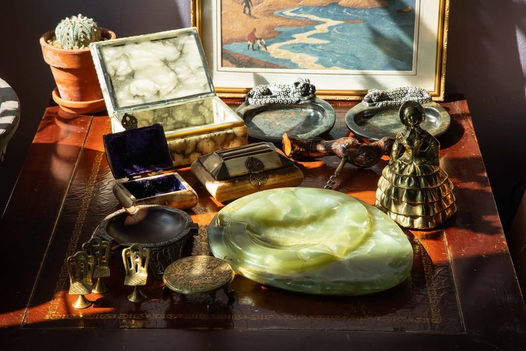Collection of decorative items on a wooden surface with a painting in the background