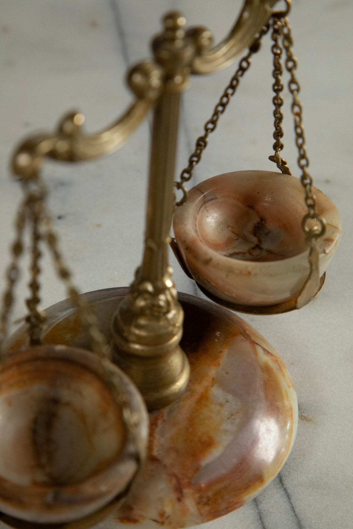 Decorative scale with marble-like base and brass accents on a light background