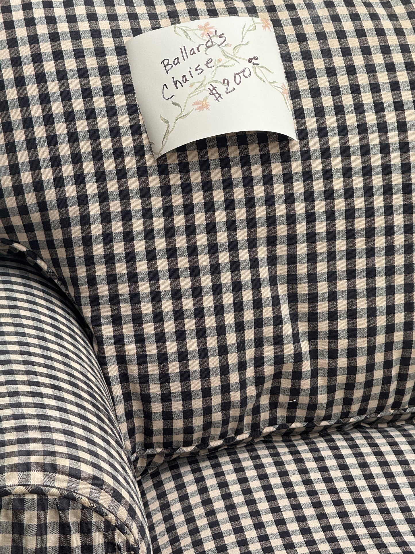 Close-up of a black and beige gingham check fabric chaise.