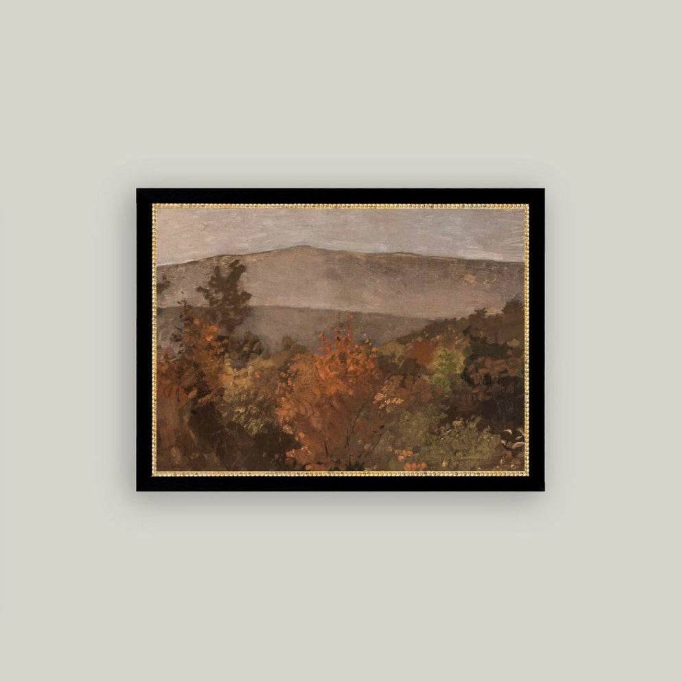 Framed landscape painting of a mountainous scene with trees on a light gray wall.