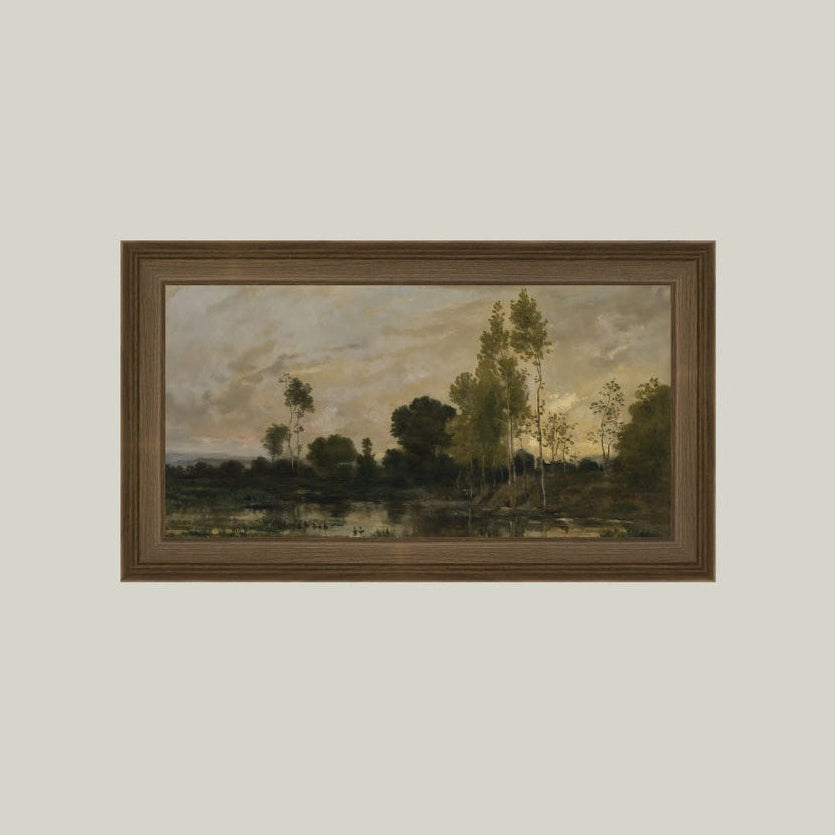 Framed painting of a landscape with trees and water on a plain wall.
