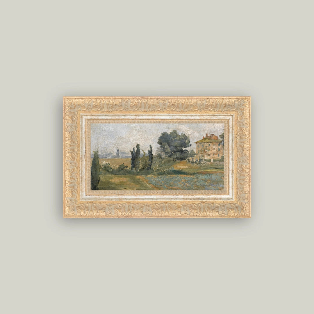 Framed painting of a landscape with trees and a building on a light gray wall
