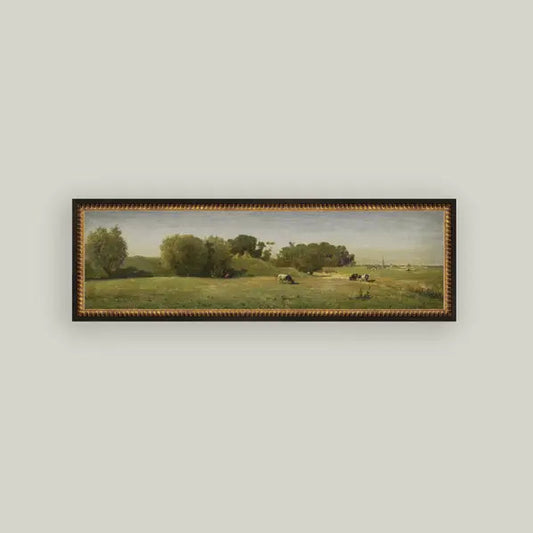 Framed landscape painting of a field with trees on a light gray wall