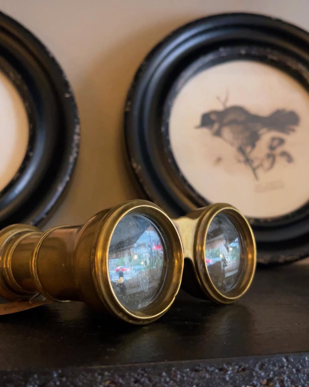 Vintage-style binoculars on a textured surface with a blurred background